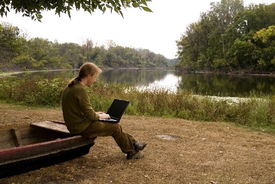 A man is working with her nootebook in outdoors