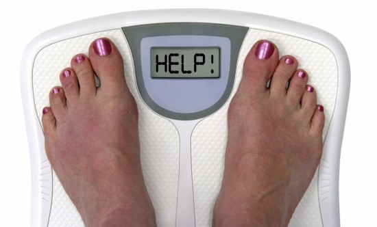 Feet on a bathroom scale with the word help! on the screen. Isolated.  Includes clipping path.