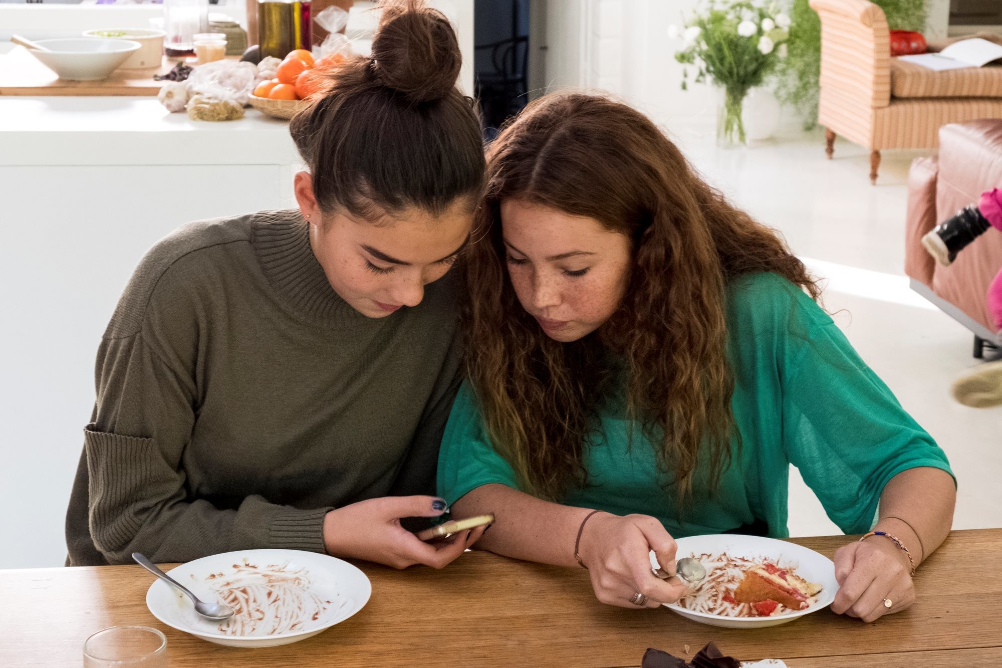 Dos chicas adolescentes miran un teléfono móvil