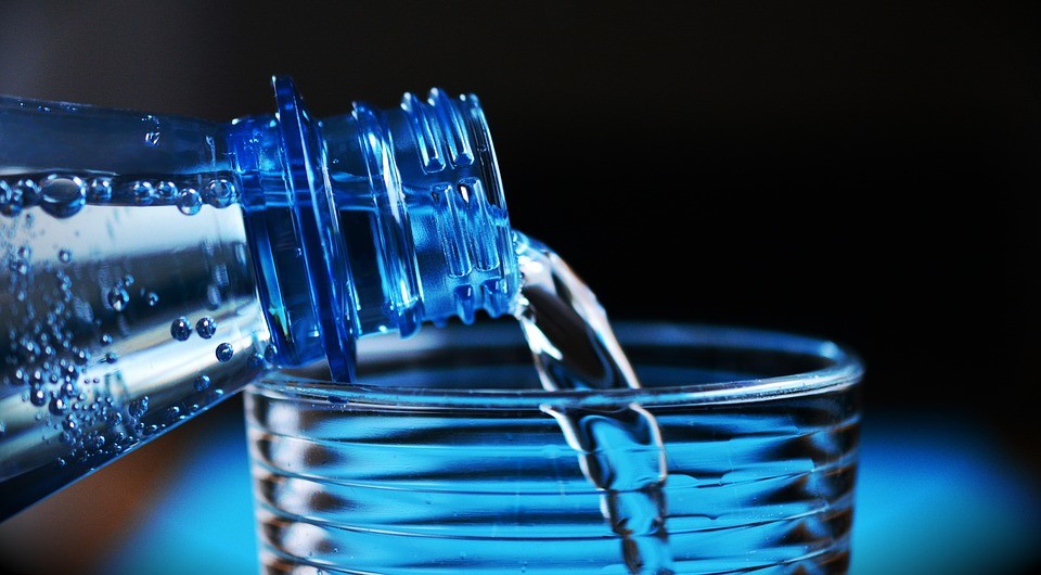 Botella vertiendo agua en un vaso