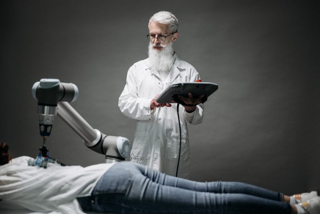 Un médico atendiendo a un paciente a través de un brazo robotizado