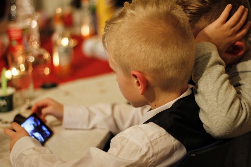 Dos niños viendo un móvil en un restaurante